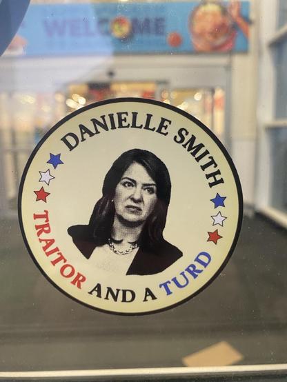 A sticker at the entrance of a grocery store:

Danielle Smith a Traitor and a Turd