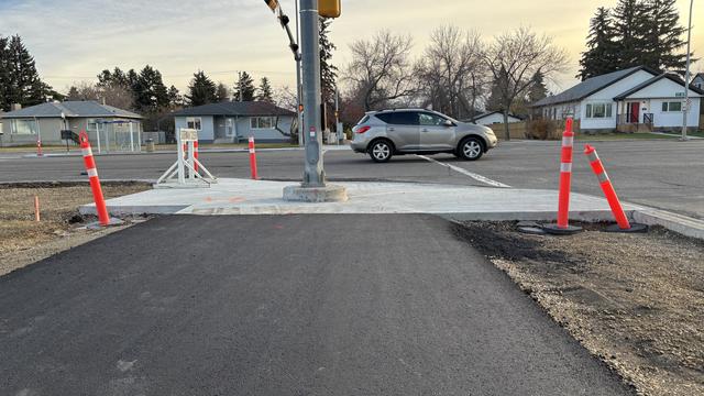 Brand new pole for traffic lights placed right in the middle of a brand new asphalt path