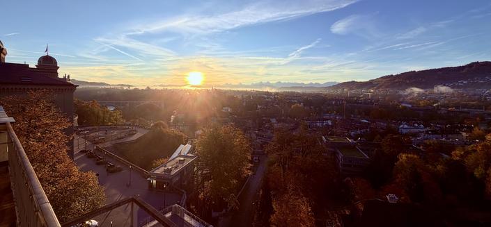 Blick auf den Sonnenaufgang, die Berner Alpen und die herbstliche Stadt