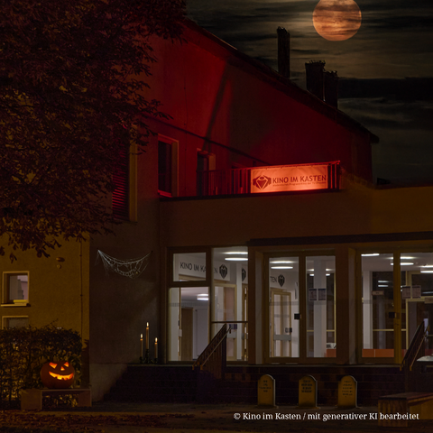 Foto vom Lehrgebäude der TU Dresden in der August-Bebel-Straße. Es ist dunkel. Das Bild zeigt den Eingangsbereich des Gebäudes. Darüber ist ein Schild angebracht, das auf das Kino im Kasten verweist.
Mit Hilfe von generativer KI sind Halloweenmotive ergänzt worden - darunter ein geschnitzter Kürbis, Spinnenweben am Gebäude, Kerzen, Grabsteine und ein blutroter Vollmond.