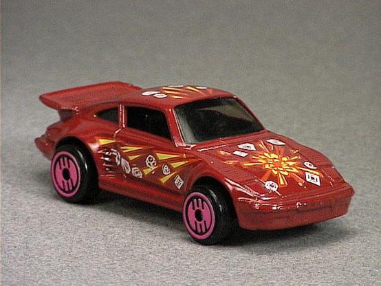 Released in 1993, Metal Flake Red Porsche 930 of Revealers with Ultra Hot wheels. Tampo: Orange yellow and white tampo all over. Packaging: Revealers 10 Pack. Metal Body, Metal Base. Made in Malaysia. Scarcity: 2/10
