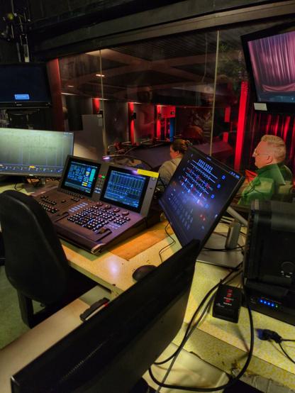 The lighting control system and other equipment. A man in a green jacket is standing just outside the window.