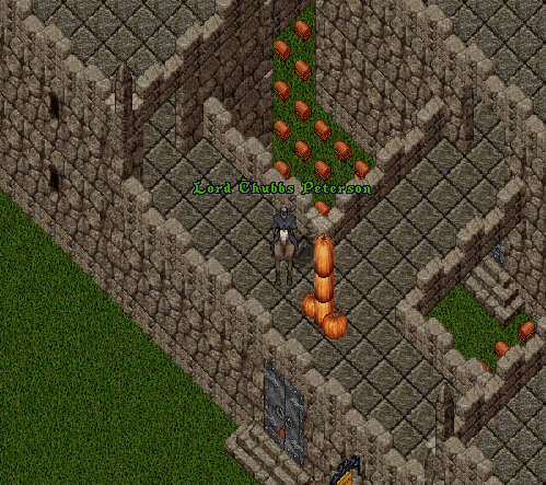 A stone castle stands on a field. The proud owner of the castle stands on the wall, organizing his pumpkins from the fall harvest