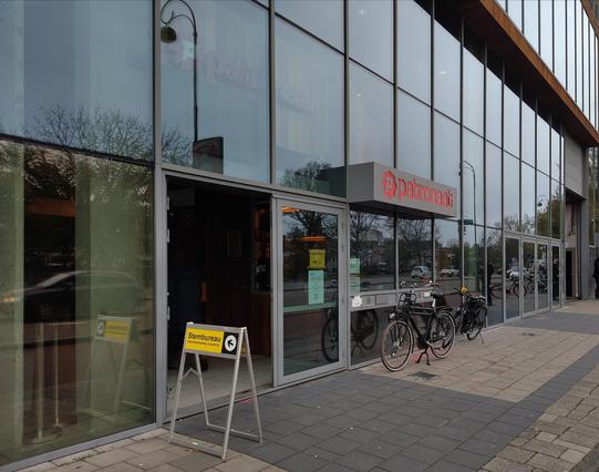 Ingang muziekpodium Het Patronaat in Haarlem. Voor de deur staat een geel bordje 'Stembureau'
