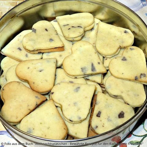 Anis-Schokoherzen in der Dose. In den hellgelben Kekse scheinen die Schokoladensplitter braun durch.
