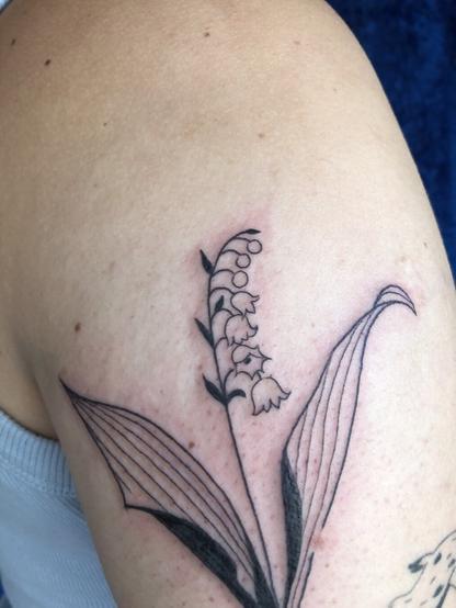 Focus sur le brin de muguet tatoué