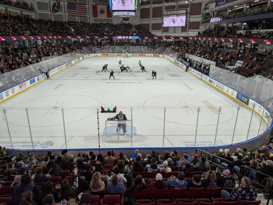 View of the hockey rink with both teams getting ready to restart play from the Blue Line at center rink.