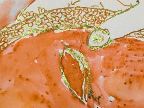 A close up of the shining flower nail art on the thumb near the eyehole of the mask, a shiny green-gold against russet.