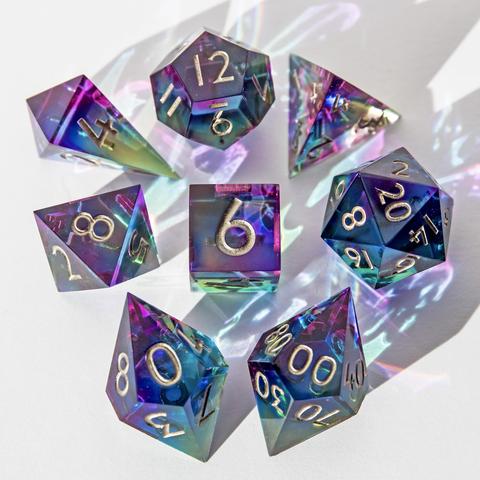 Hier ist wieder das ganze bunte Set auf weißem Untergrund zu sehen. Im vordergrund und im Fokus liegen D10 und D00, die Würfel sind mit der höchsten Seite nach oben um den D6 angeordnet. Die Würfel im Hintergrund sind etwas unscharf abgebildet.