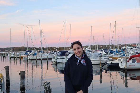 Büsra in Aalborg at the port, sailboats in the background