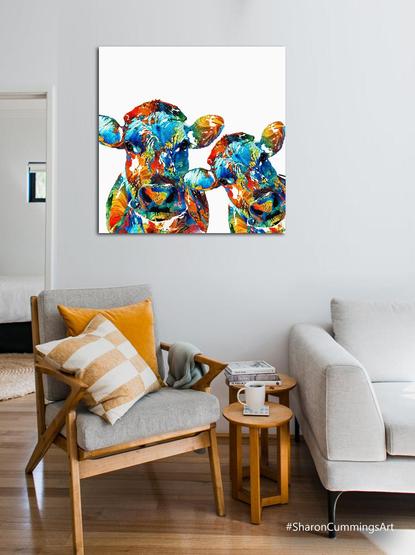 Colorful cows in a humorous pose in a furniture setting by artist Sharon Cummings.