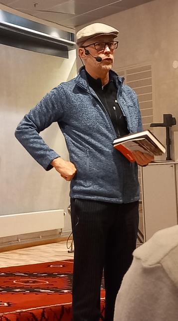 En man i keps håller i en bok