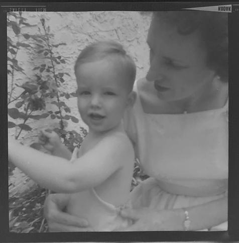 Black and white shot of a woman with a toddler. He's wearing a romper and no shirt, she's wearing a light-colored dress.