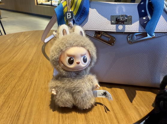 <p>中国のアートトイ大手、泡泡瑪特国際集団(POP MART、ポップマート)の株価が連日下落している。10月23日に発売された設立15周年記念シリーズ「Celebrating The Moment」の販売が、当初の期待を下回り、投資家心理の冷え込みにつながったとみられる。</p>
<figure class="wp-caption aligncenter" id="attachment_441620" style="width: 622px;"><img alt="" class="wp-image-441620 size-full" height="924" src="https://36krjp-1316517779.cos.ap-tokyo.myqcloud.com/uploads/2025/10/20251030000043screenshot143.png" width="622" /><figcaption class="wp-caption-text" id="caption-attachment-441620">設立15周年記念シリーズ「Celebrating The Moment」=公式サイトより</figcaption></figure>
<p>今回の新シリーズは、人気キャラクター「LABUBU(ラブブ)」、「MOLLY(モリー)」、「DIMOO(ディムー)」などを集めた通常モデル15種とシークレット1種で構成される。シークレットモデル「Party Sweetie MOLLY」は発売価格69元(約1500円)に対し、519元(約1万1000円)まで高騰し、約7.5倍のプレミアムがついた。しかし、通常モデルのプレミアムは2倍前後にとどまり、以前ほどの勢いは見られなかった。</p>
<p>一方で、ポップマートは今年も複数のヒット商品を生み出している。なかでも米人気ドラマ「Wednesday(ウェンズデー)」とのコラボによるSKULLPANDAシリーズが話題を呼んだ。北米限定の「ネヴァーモア学園制服バージョン」は、劇中の細部まで忠実に再現したことで評価され、価格は399元(約8400円)から5499元(約12万円)へと上昇した。また、今年初めには、中国のアニメ映画「ナタ・魔童の海騒動(ナタ2)」とのコラボによるシークレットモデルも登場し、価格が発売時の約16倍まで高騰している。</p>
<p>ポップマートの株価は9月以降、累計30%近くまで下落。10月23日には一時約10%安となり、この半年で最大の下げ幅を記録した。アナリストは、「投資家が成長率のピークアウトを懸念している」と指摘する。もっとも、同社の7〜9月期の業績は依然として堅調で、売上高は前年同期比245〜250%増加し、海外市場では360%を超える伸びを見せた。</p>
<p>*1元=約21円で計算しています。</p>
<p>(36Kr Japan編集部・茶谷弥生)</p>