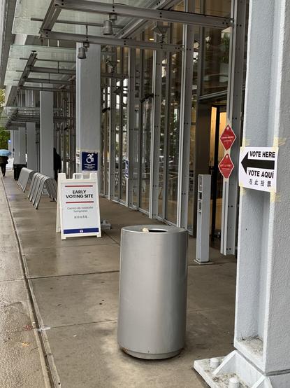 Signage for early voting with arrow saying “vote here” and “vote aqui”