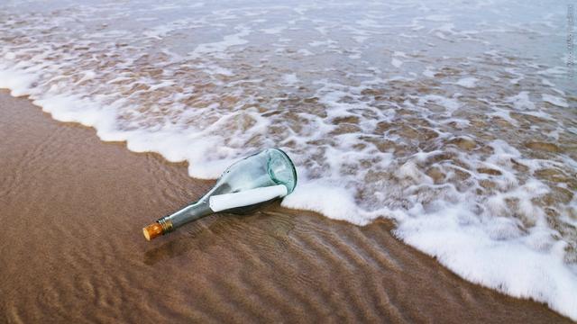 Eine Flasche mit Brief wird am Strand angespült (Symbolbild). (Foto: IMAGO, IMAGO / SuperStock)