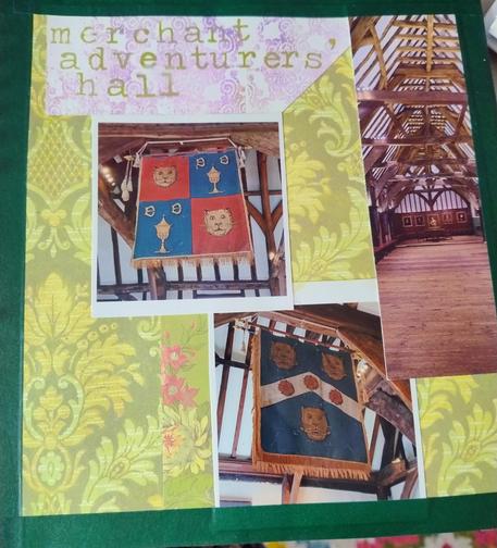 Green background scrapbook page with photos from a medieval hall on it. The two main photos show guild crest flags of ugly cats and chalices