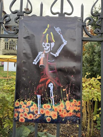 Ein Plakat zeigt ein farbenfrohes Skelett, welches eine Flöte spielt
A poster shows a colorful skeleton playing a flute