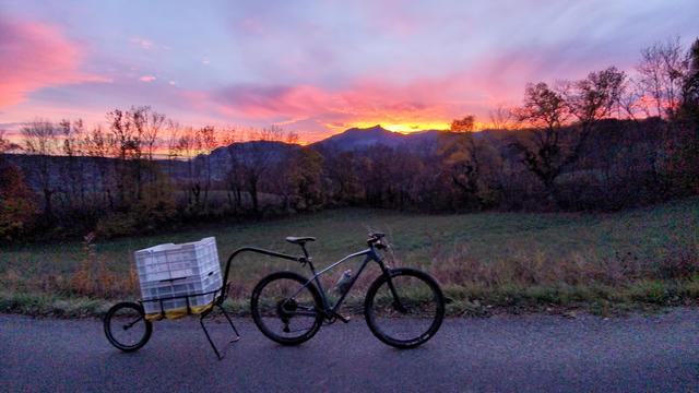 Vélo avec une remorque en arrière plan montagnes au soleil couchant