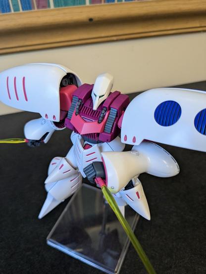 The HG Qubeley on a flight stand lunging toward the viewer wielding both beam sabers, one in a reverse grip.