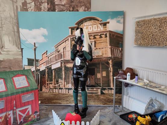 Righin posing as a pony in full tack. He has been tied to a table and is in the process of wrapping the leash around himself until he gets stuck.