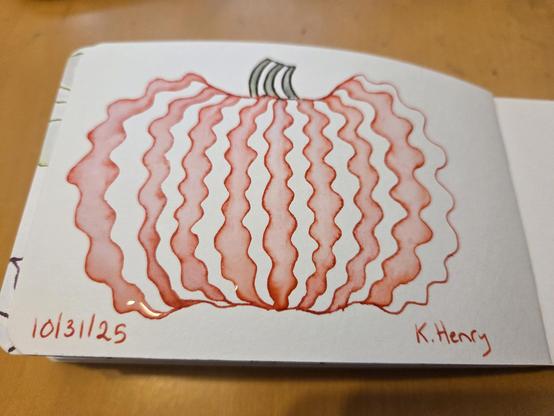 Hand drawn generative/procedural art in ink on an open page of my sketchbook. The abstract pattern looks a bit like a wavy pumpkin with a short stem.