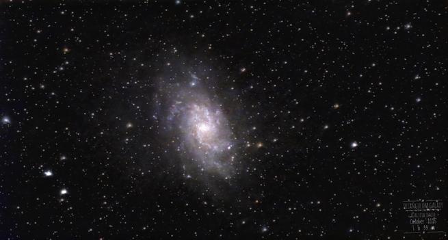 A large spiral Galaxy with multiple arms, the Triangulum Galaxy, dominates the scene amidst a medium star field.