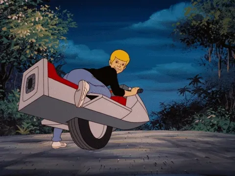 Two boys and a dog ride two one-wheeled motorcycles through a forest