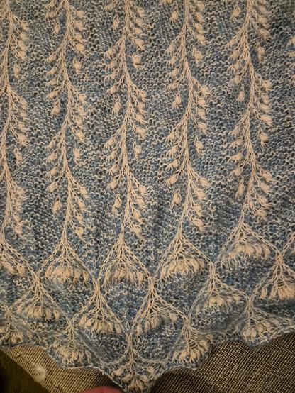 Nähere Aufnahme eines Ausschnitts des gestrickten Tuches, bei dem die Muster von Hauptteil und Rand besser erkennbar sind