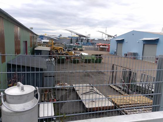 Ein Blick vom Bahnsteig Sinsheim Arena auf das Gelände des Technikmuseums mit Concorde und Tupolev-144 im Hintergrund. Im Vordergrund links steht eine 5l-Milchkanne die eben am Milchautomat vom Würfelhof befüllt worden war.