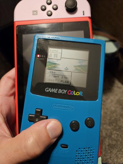 Photo of a game boy color, playing dragon warrior 1, with a Nintendo switch under it.