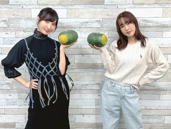 Two women smiling holding pumpkins.