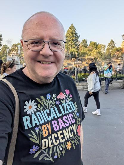 A picture of me, a middle-aged white man, wearing a t-shirt with the slogan "Radicalized by Basic Decency" and a decorative floral pattern.

Picture is taken in New Orleans Square at Disneyland, California.