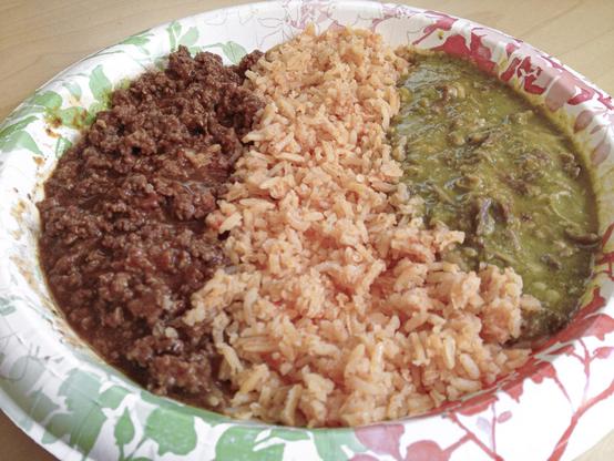Paper plate full of ground beef chili colorado, Mexican rice, and pork chili verde.