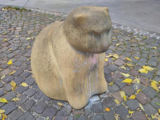 Fat cat made of stone sitting on the street.