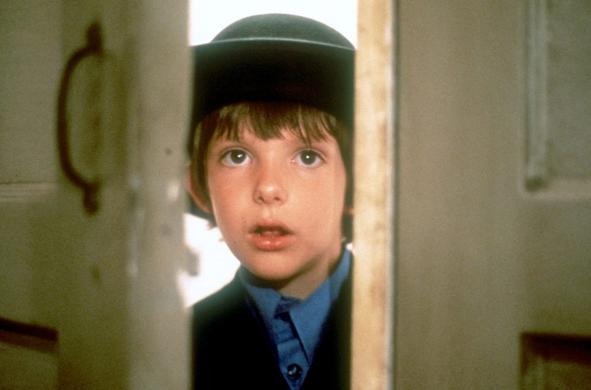 Ein Junge schaut durch den Spalt einer Tür. Der einzige Zeuge Samuel (Lukas Haas), ein Junge aus der Gemeinschaft der Amish, ist der einzige Zeuge eines Mordfalls. (© 2003 by Paramount Pictures/All rights reserved, Foto: ARD)