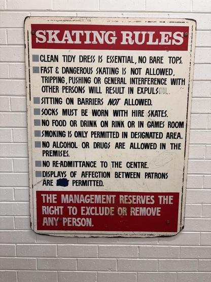 Sign reads:

SKATING RULES
CLEAN TIDY DRESS IS ESSENTIAL, NO BARE TOPS.
FAST & DANGEROUS SKATING IS NOT ALLOWED, TRIPPING, PUSHING OR GENERAL INTERFERENCE WITH OTHER PERSONS WILL RESULT IN EXPULSOTA-SITTING ON BARRIERS NOT ALLOWED.
SOCKS MUST BE WORN WITH HIRE SKATES.
NO FOOD OR DRINK ON RINK OR IN GAMES ROOM SMOKING IS ONLY PERMITTED IN DESIGNATED AREA.
NO ALCOHOL OR DRUGS ARE ALLOWED IN THE PREMISES.
NO READMITTANCE TO THE CENTRE.
DISPLAYS OF AFFECTION BETWEEN PATRONS
ARE 1
PERMITTED.
THE MANAGEMENT RESERVES THE RIGHT TO EXCLUDE OR REMOVE ANY PERSON