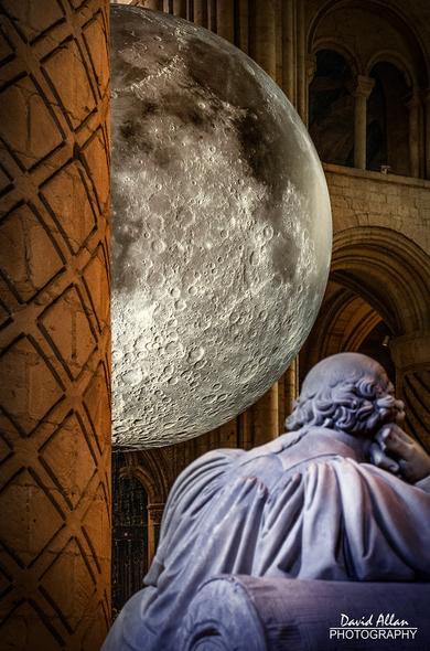 A partial lunar eclipse – Luke Jerram's 'Museum of the Moon' appearing from behind Durham Cathedral's ancient Norman architecture.