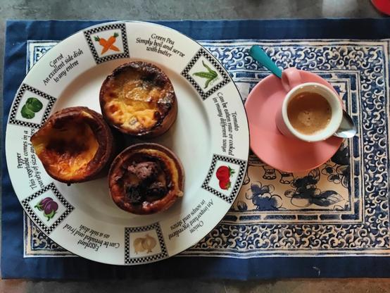 3 fondants à côté d'une tasse de café sur un set de table à motif bleus