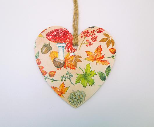 A wooden shaped hanging heart with a decoupage picture of autumn leaves, a toadstool and fircones, a perfect little gift for an autumn birthday