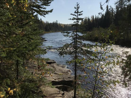 Lovely view of the Pigeon River at the far end of the Grand Portage trail in northeastern Minnesota. Conifers galore, blue water, rocky shoreline. That's Canada on the right.