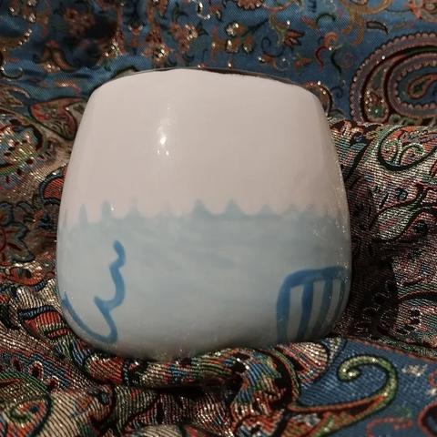 Photo de l'arrière de la tasse. On voit la petite queue de la perruche.