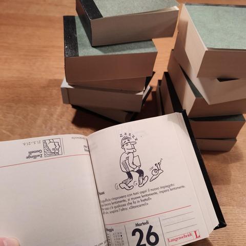foto eines italienisch-sprachkalenders, der fest gebunden wurde, vor einem stapel weiterer kalender