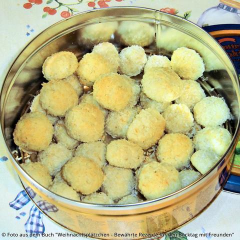 Auf dem Tisch eine gelbe Dose mit gelben Kokoskugeln.