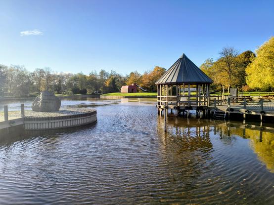 Ein See mit einem Pavillon und Gelenkschein in der Herbstsonne