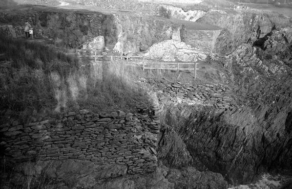 La photo en noir et blanc représente des murs destinés à stabiliser des plateformes (ou daviers) en bord de falaise pour la récolte du goémon, qui transformé permettait la fabrication artisanale de la soude et de l'iode. Elle a été prise dans le Finistère (Bretagne) près de Douëlan