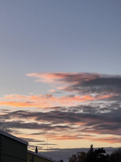 Auf dem Foto sieht man einen Sonnenuntergang. Der Himmel ist halb bedeckt mit Wolken. Sie werden vom letzten Licht der Sonne angestrahlt. Das gibt ihnen besondere Farben. Der Rest des Himmels strahlt in einem leicht blassen Blau