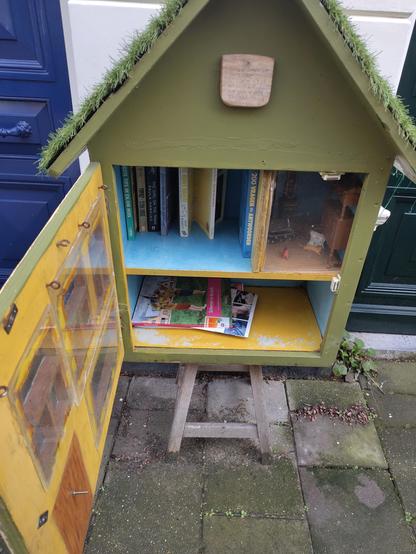 Klein boekenkastje met puntdak en twee etages.