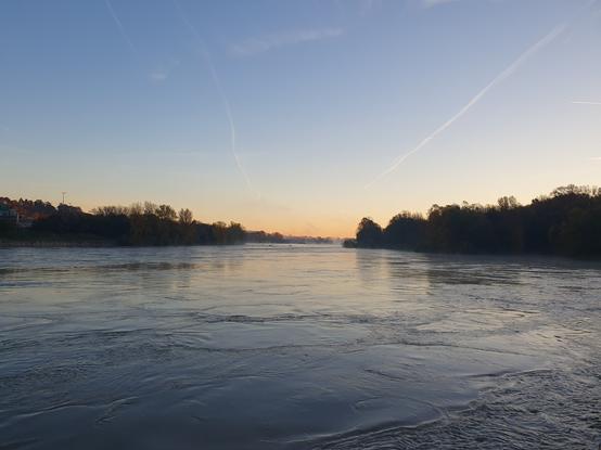the Rhône, slowly running between trees, blue and pink sky relfectng on her slightly disturbed waters