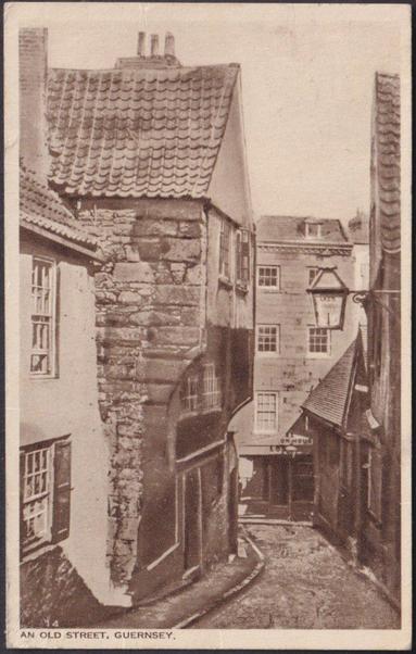 Printed sepia postcard showing a view of an unnamed old street on Guernsey, actually Pollet Street at St Peter Port.

Published by Birn Brothers, London, British Photogravure Series, not numbered.

Postally used on 26 July 1947 with Guernsey cancellation on orange 2d stamp and sent to Miss B. Pomeroy, 4 Orion Cottages, Bath Road, Cranford, Middlesex, England.

Very good condition, with very slight corner bumps.